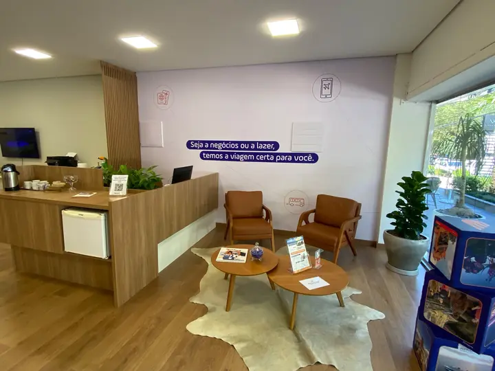 Recepção corporativa com mobiliário de madeira e plantas ornamentais