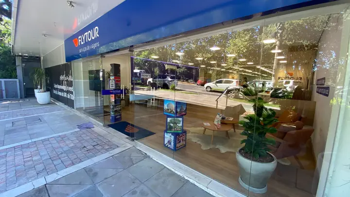 Fachada envidraçada de agência com vaso ornamental na entrada